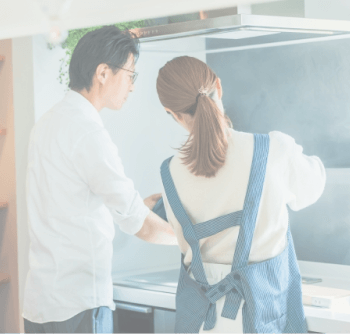 家のキッチンで夫婦が料理をしている画像